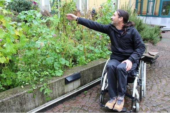Arnaud en chaise roulante dans le jardin 